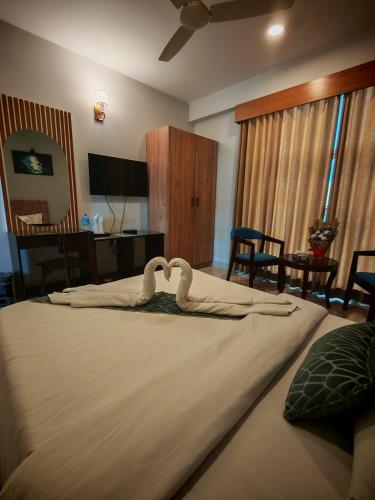 a bedroom with a bed with swans on it at Sylhet Paradise Inn in Sylhet