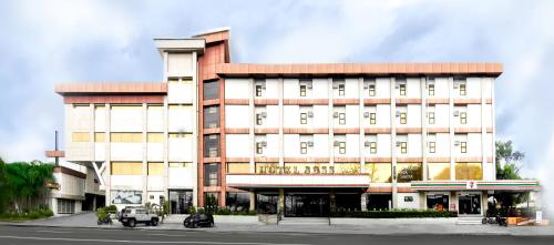 a building with a car parked in front of it at Dancenter Boss Hotel Near Clark International Airport in Angeles
