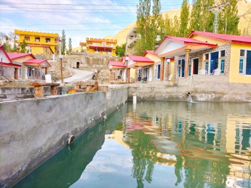 a group of houses next to a body of water at Skardu View Point Hotel and Huts in Skardu