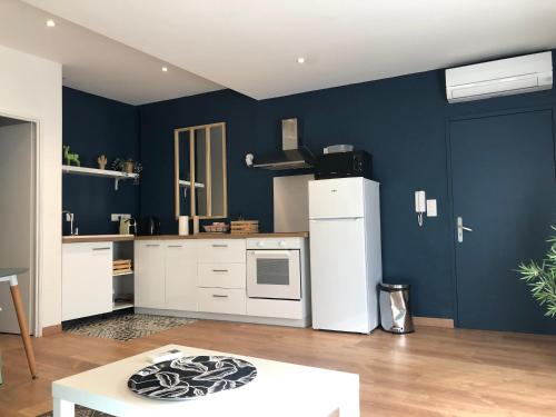 cocina con paredes azules y nevera blanca en Nomad's house - 2G, en Aviñón