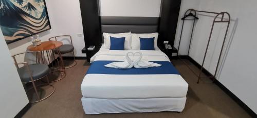 a bedroom with a bed with two white towels on it at Dancenter Boss Hotel Near Clark International Airport in Angeles