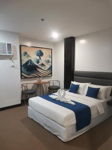 a bedroom with a large bed with blue and white sheets at Dancenter Boss Hotel Near Clark International Airport in Angeles