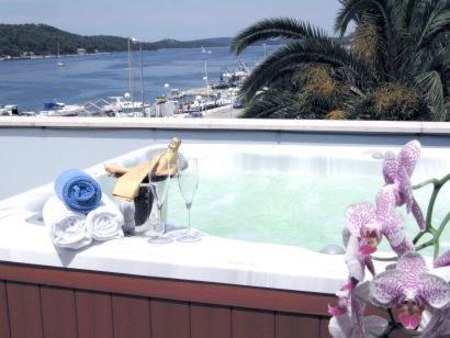 a figurine sitting on a ledge next to a swimming pool at Mare Mare Suites in Mali Lošinj
