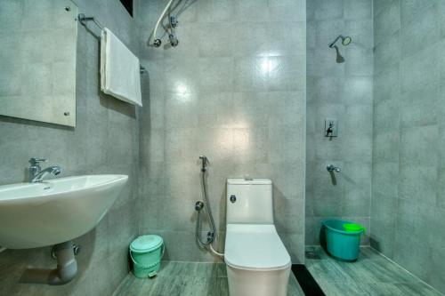 a bathroom with a white toilet and a sink at Corbelli Residency in Puducherry