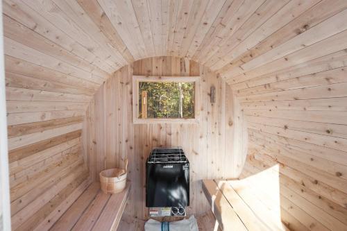 Spa and Sauna - Riverside - Brand New- SKOV Chalets في Saint Come: كابينة خشبية مع موقد في المنتصف