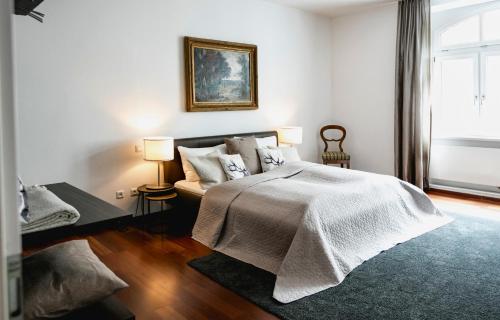 a white bedroom with a bed and a couch at My Wonderland in Salzburg