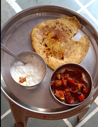 a plate of food with a bowl of food and toast at Little Ganesha Inn in Jaipur