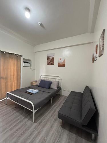a bedroom with a bed and a couch in it at Davao Condo Near Airport & Malls in Davao City