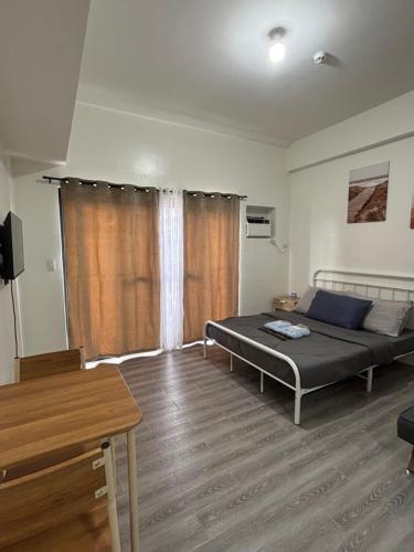 a bedroom with a bed in the middle of a room at Davao Condo Near Airport & Malls in Davao City