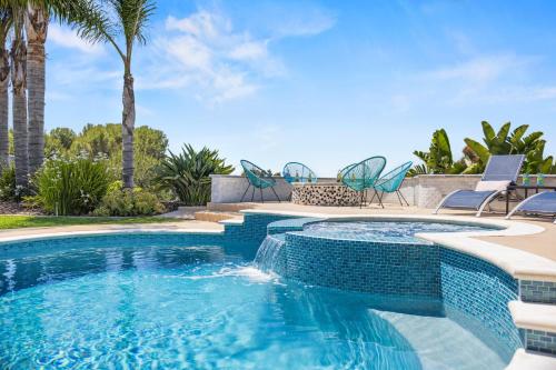 a swimming pool with chairs and palm trees at SoCal Gem Pool, Spa, Games, and Scenic Views in Oceanside