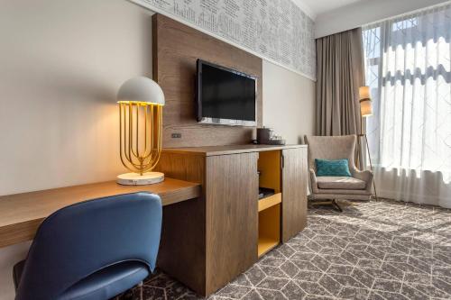 a hotel room with a desk with a tv and a chair at Bluegreen Vacations Hotel Blake, an Ascend Collection Hotel in Chicago