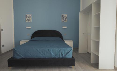 a bedroom with a bed with a blue wall at Mhometredici Guest House in Sestu