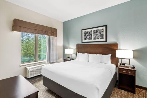 ein Hotelzimmer mit einem großen Bett und einem Fenster in der Unterkunft MainStay Suites Lufkin in Lufkin
