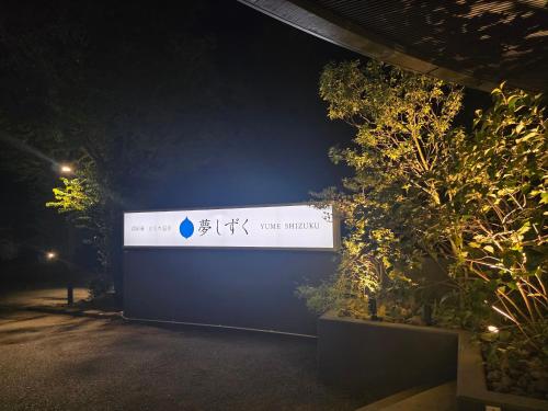 a sign for a building with writing on it at night at Hotel Yumeshizuku in Minami Aso