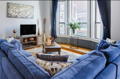 a living room with a blue couch and a tv at Free Parking Loft Suite Walk to Conv Center in San Diego
