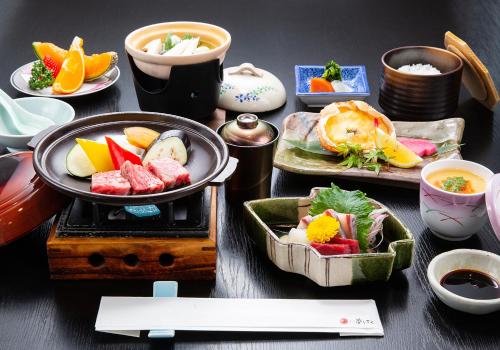 a table with plates of food and bowls of sushi at Hotel Yumeshizuku in Minami Aso