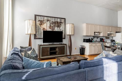 a living room with a blue couch and a tv at Free Parking Loft Suite Walk to Conv Center in San Diego