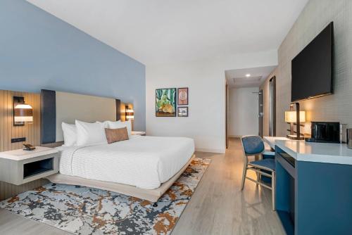 a hotel room with a large bed and a kitchen at Cambria Hotel Austin Downtown in Austin