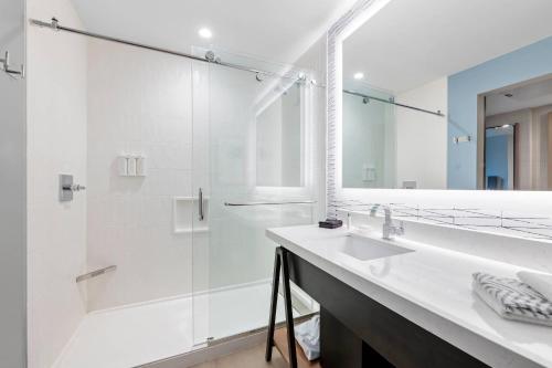 a white bathroom with a sink and a shower at Cambria Hotel Austin Downtown in Austin