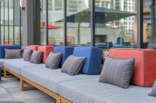 a row of benches with colorful pillows on them at Cambria Hotel Austin Downtown in Austin