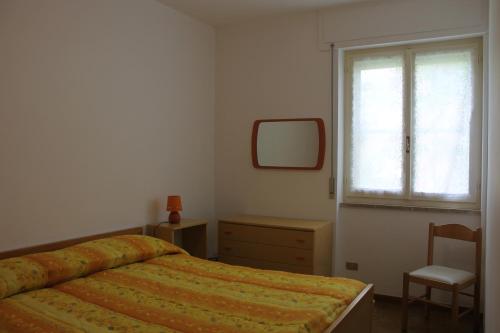アルゲーロにあるAppartamento La Palmaのベッドルーム1室(ベッド1台、椅子、窓付)