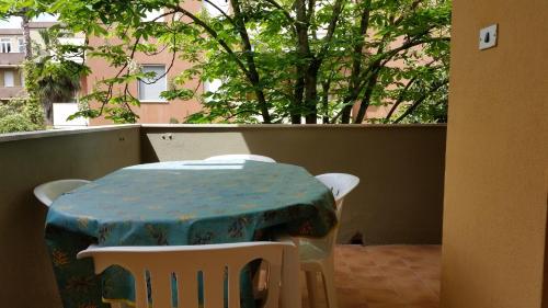 アルゲーロにあるAppartamento La Palmaの木のあるバルコニー(テーブル、椅子付)
