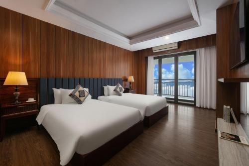 a hotel room with two beds and a balcony at Bamboo Sapa Hotel in Sa Pa