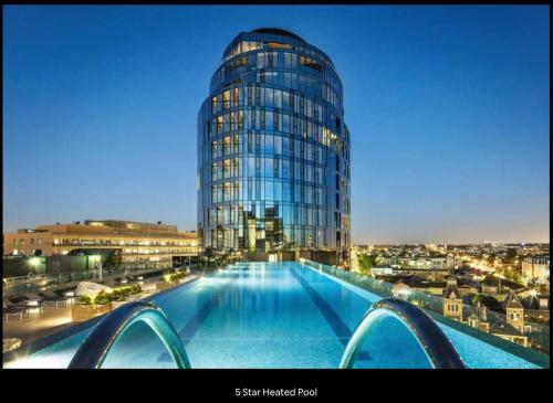 a large glass building with a pool in front of it at Executive Two bedroom & two bathrooms in Melbourne