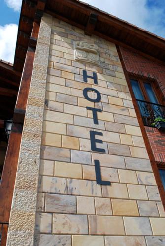 a tall brick building with the word faith on it at Hotel y Apartamentos Sur de la Bahía in Elechas