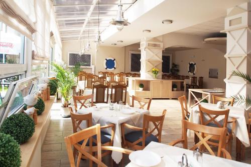 a restaurant with tables and chairs in a room at ELPAK Świnoujście in Świnoujście