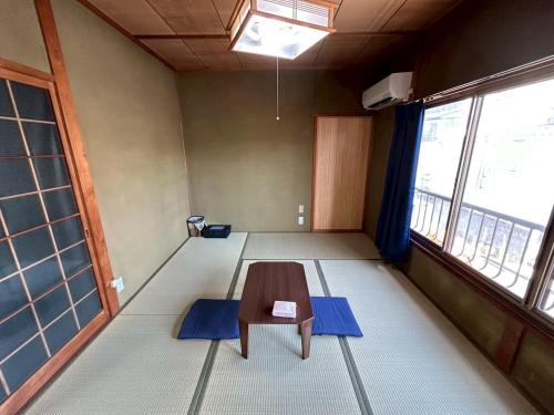 a room with a table in the middle of a room at Denim-yado Ken-健- in Tamano
