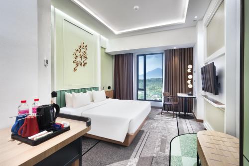 美娜多Luwansa Hotel and Convention Center Manado的一间带床和电视的酒店房间