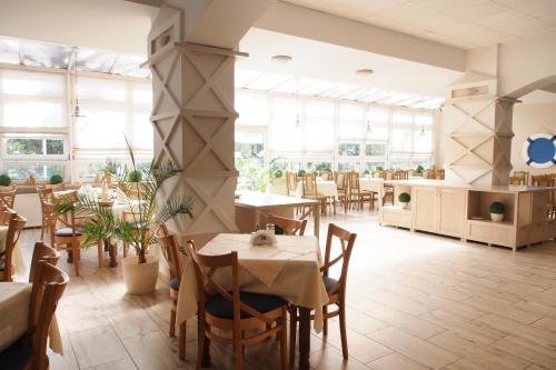 a restaurant with tables and chairs and large windows at ELPAK Świnoujście in Świnoujście