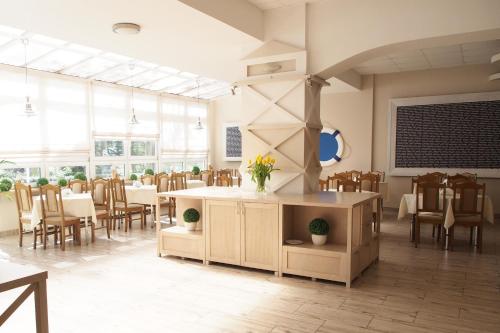 a dining room with tables and chairs and windows at ELPAK Świnoujście in Świnoujście
