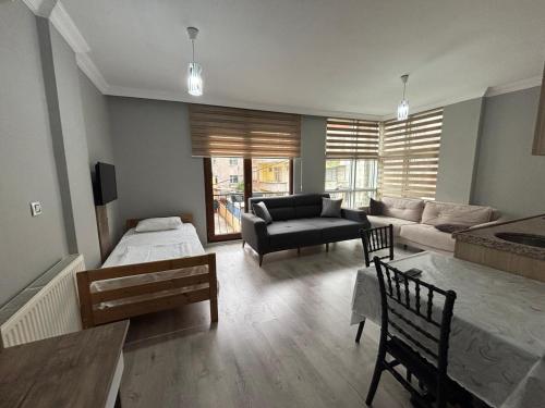 a living room with a couch and a bed and a table at SİMGE Apt in Trabzon