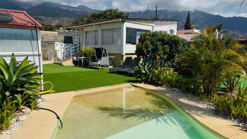 a backyard with a swimming pool and a house at Finca Maradentro - private pool and jacuzzi with ocean view in Arafo