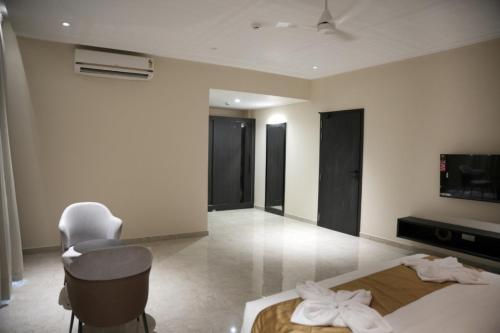 a hotel room with a bed and a chair and a television at Alba Regency in Guruvāyūr