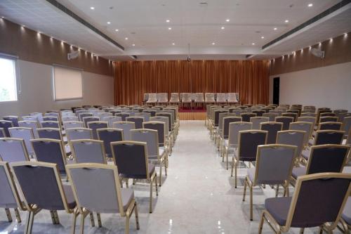 an empty room with chairs and a podium in the background at Alba Regency in Guruvāyūr