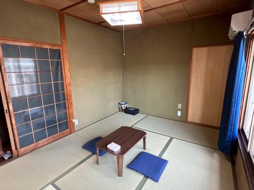 an empty room with a chair and a window at Denim-yado Ken-健- in Tamano