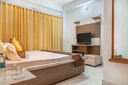 a bedroom with a bed and a television at ExoticStays l Empire Kasauli in Kasauli