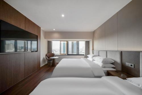 a row of beds in a hotel room at Crystal Hotel Daegu in Daegu