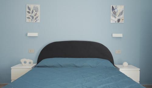 a bedroom with a bed with a black head board at Mhometredici Guest House in Sestu