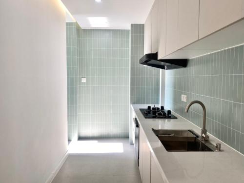 a kitchen with white cabinets and a sink at Urban Hub Near the Bund nice view big apartment 2bathrooms in Shanghai
