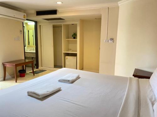 a bedroom with a bed with two towels on it at Jumbotel Hotel in Bangkok