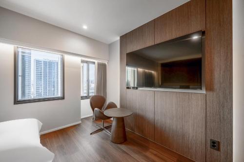 a bedroom with a bed and a table and a tv at Crystal Hotel Daegu in Daegu