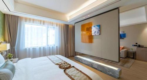 a bedroom with a large white bed and a window at GreenTree Eastern Dali Railway Station Hotel in Dali
