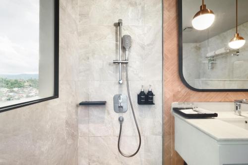 a bathroom with a shower and a sink at Luwansa Hotel and Convention Center Manado in Manado