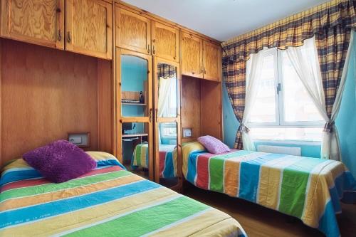a bedroom with two beds and a window at Vivienda turística Felicia in León