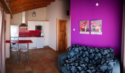 a living room with a couch and a purple wall at Hotel y Apartamentos Sur de la Bahía in Elechas