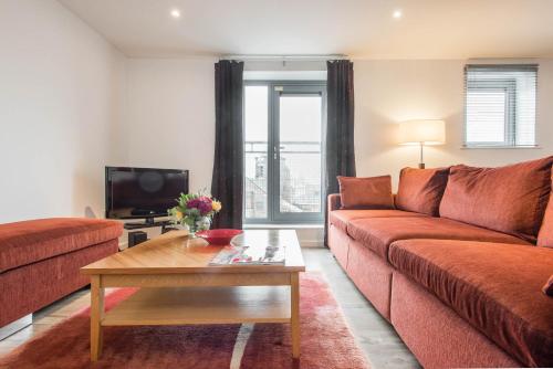a living room with a couch and a coffee table at PREMIER SUITES Newcastle in Newcastle upon Tyne